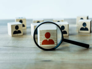 selective focus of magnifying glass near cubes on wooden desk