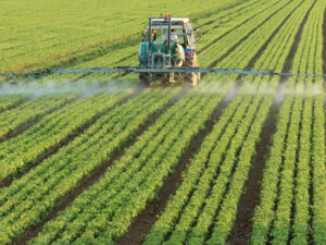 Farming tractor spraying a field